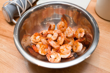 A metal bowl of fried shrimp in spices with unpeeled tails, lots of tasty seafood