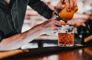 man bartender hand making negroni cocktail. Negroni classic cocktail and gin short drink with sweet...