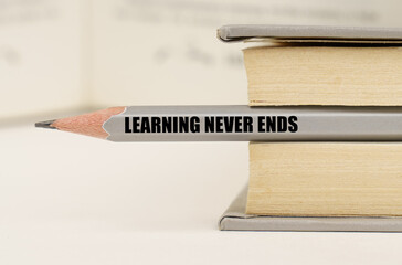 In the book between the pages lies a pencil with the inscription - Learning never ends