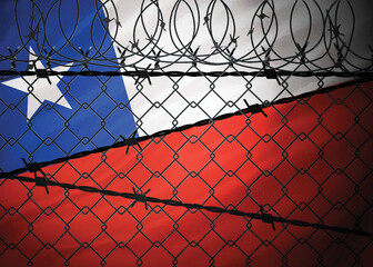 Chile flag behind barbed wire and metal fence