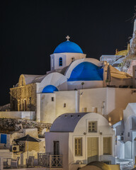 Typical church in Oia village (Santorini) with blue dome at night, Greece.