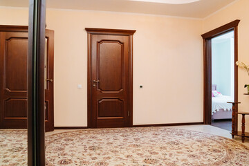 entrance hall with interior doors made of brown wood. 