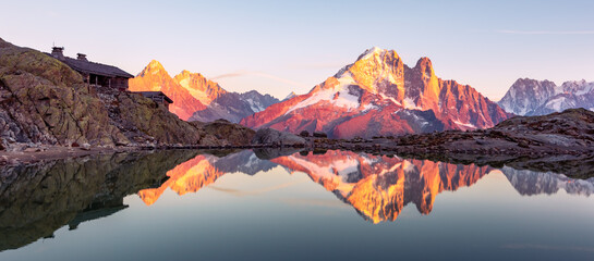 Obraz premium Colourful sunset on Lac Blanc lake in France Alps. Monte Bianco mountain range on background. Vallon de Berard Nature Preserve, Chamonix, Graian Alps. Landscape photography