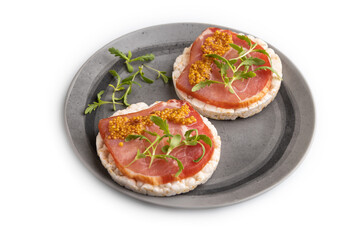 Puffed rice cake sandwiches with jerky salted meat, microgreen isolated on white, side view, close up.
