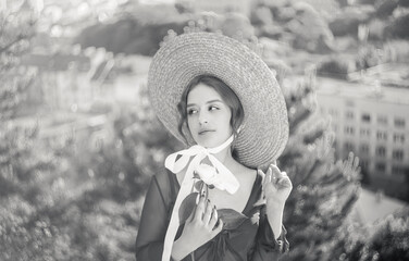 Close-up black and white portrait of a cute blonde in a straw hat at sunset. Vintage tone..Soft...