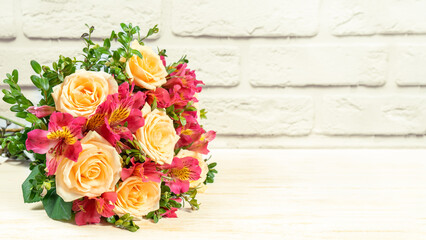 Bouquet of beautiful roses and alstroemeria on white brick background. Fresh, lush bouquet of colorful flowers for wedding, valenitnes day, mother day. Floral shop concept, mockup with copy space