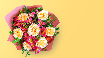 Bouquet of beautiful roses and alstroemeria on yellow background. Fresh, lush bouquet of colorful...