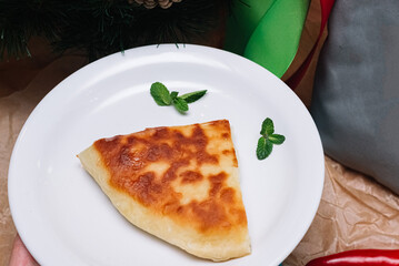 a slice of cheese pie. a traditional Georgian khachapuri cheese pie. a portion for one served on a plate.