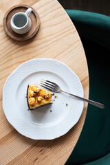 caramel cheesecake with popcorn and salted caramel sauce on white plate, selective focus