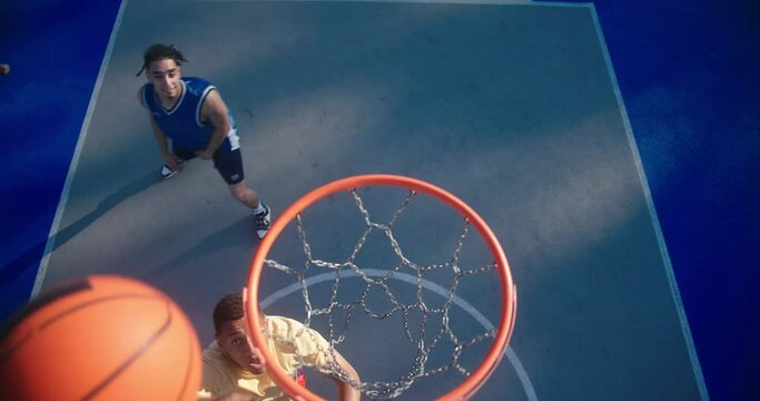 Basketball team scores ball in hoop and smiles to each other