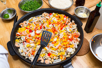 Seafood fried in a paella dish (paella pan) with chopped bell pepper pieces. Seafood cocktail. Shrimp, squid, octopus, mussels.