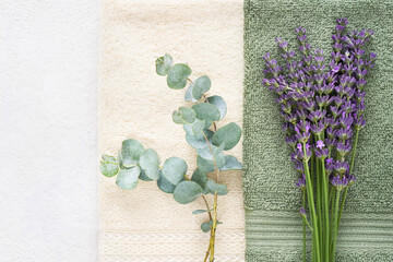 Towels, green eucalyptus and lavender on white background. Hygiene, wellness body care concept