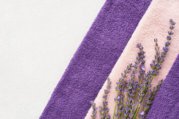 Fluffy towels and lavender on light background. Minimalist style. Wellness well-being, SPA concept