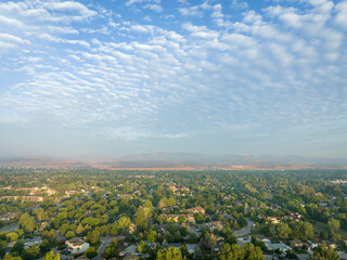 misty summer morning over Fort Collins and foothills of Rocky Mountains in northern Colorado, aerial view after heavy rainstorm with altocumulus clouds - obrazy, fototapety, plakaty