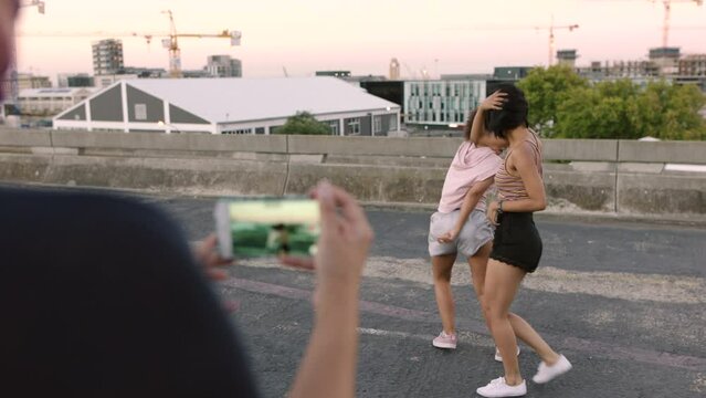 Girls dancing hip hop, salsa and tango dance expression style mixed with freestyle on an empty city street. Trendy female dancers moving and stepping together in an urban town and get taped on mobile