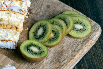 sliced green kiwi fruit on a wooden board