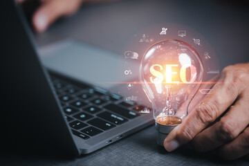 Marketer hold a light bulb showing SEO concepts, optimization analytics tools, search engine rankings, social media sites based on results analytics data. Customers use keywords to connect products