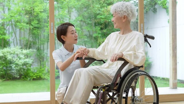車椅子に乗った女性をサポートする介護士