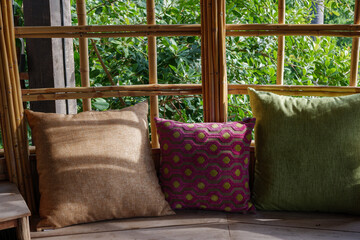 Cozy and comfortable sofa and colourful pillows with tropical atmosphere and sunshine. 