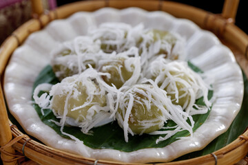  Thai coconut balls, Kha Nom Tom, on white plate and rattan basket. 