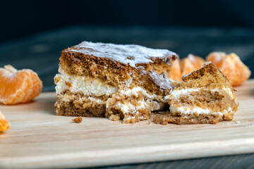 a piece of honey cake with vanilla cream and citrus tangerines
