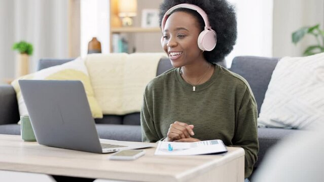 Online teacher talking on videocall using laptop and headphones while waving hello to students. Woman making note while communicating and learning new language during online course or private lesson