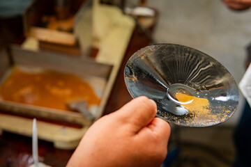 close up of a person holding a bowl with gold dust