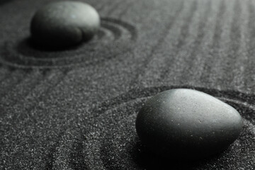 Fototapeta na wymiar Black sand with stones and beautiful pattern. Zen concept