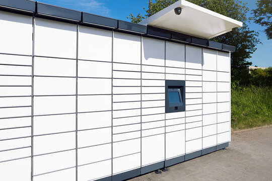 Modern parcel locker with many postal boxes outdoors