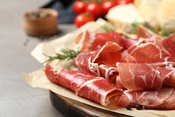 Slices of tasty prosciutto on grey table, closeup
