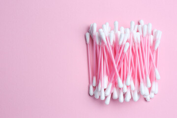 Heap of cotton buds on pink background, top view. Space for text