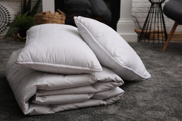 Fototapeta na wymiar Soft blanket and pillows on floor indoors
