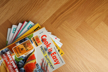Many magazines on wooden background, top view. Space for text