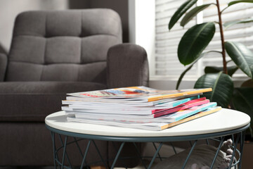 Many stacked magazines on table in room