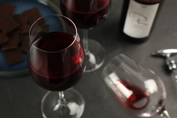 Tasty red wine and chocolate on black table, closeup. Space for text