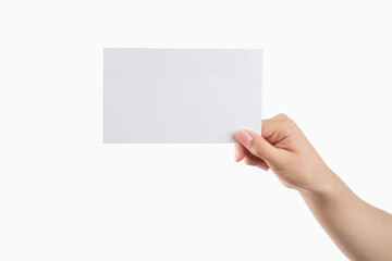 Fototapeta premium Hand of a young woman holding a white cardboard to mount an image or advertising text, with a white background