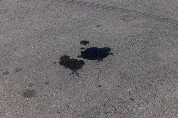 A road for vehicles covered with stains and pollution from oil and fuel of cars