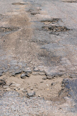 poor paved road with a lot of holes and potholes
