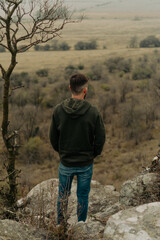 Naklejka premium Young man looking at a landscape from the heights