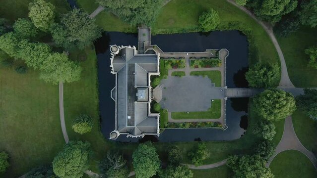Top-down View Of Schloss Evenburg Surrounded By Water With English Garden In Leer, North Germany. Aerial Descending