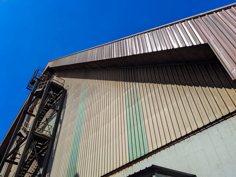 A warehouse where PKE (Palm Kernal Expeller) dust is stored against a blue sky background.