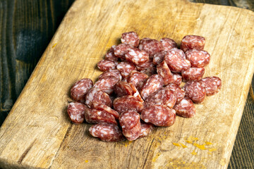 sliced thin sausage with bacon on a wooden dish