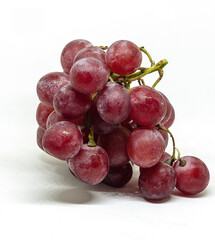Purple fresh and wet grapes on white background
