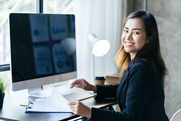 Asian woman working with laptop in her office. business financial concept.