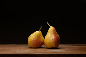 Pears on wood against black background
