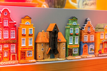 Rows of fridge magnet souvenirs from Gdansk displayed on stillage. Model houses magnets on display...