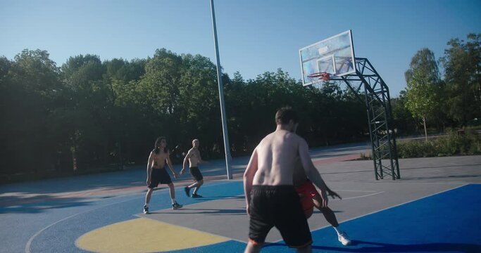 Basketball players with bare torsos play basketball on court