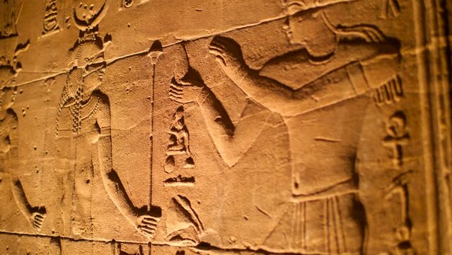 Details of hieroglyphs litten by artificial light inside the temple of Philae, Aswan, Egypt.