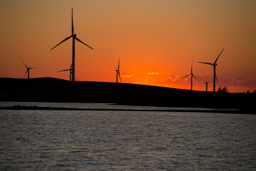 Wind turbines against the background of the red sky.