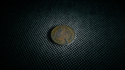 Indian old one rupee coin in dark background.